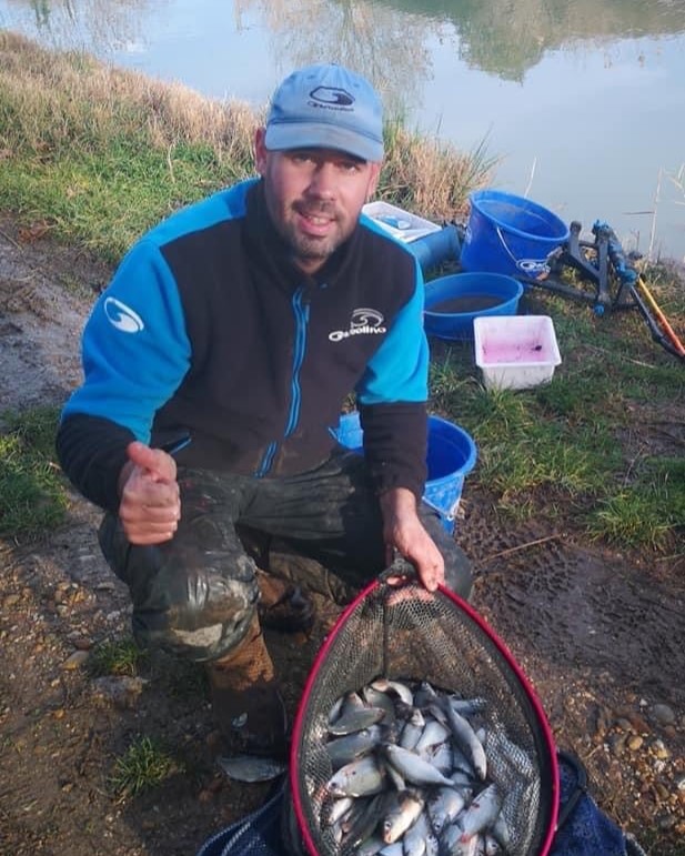 homme avec un pouce en l'air et une bourriche pleine de poissons