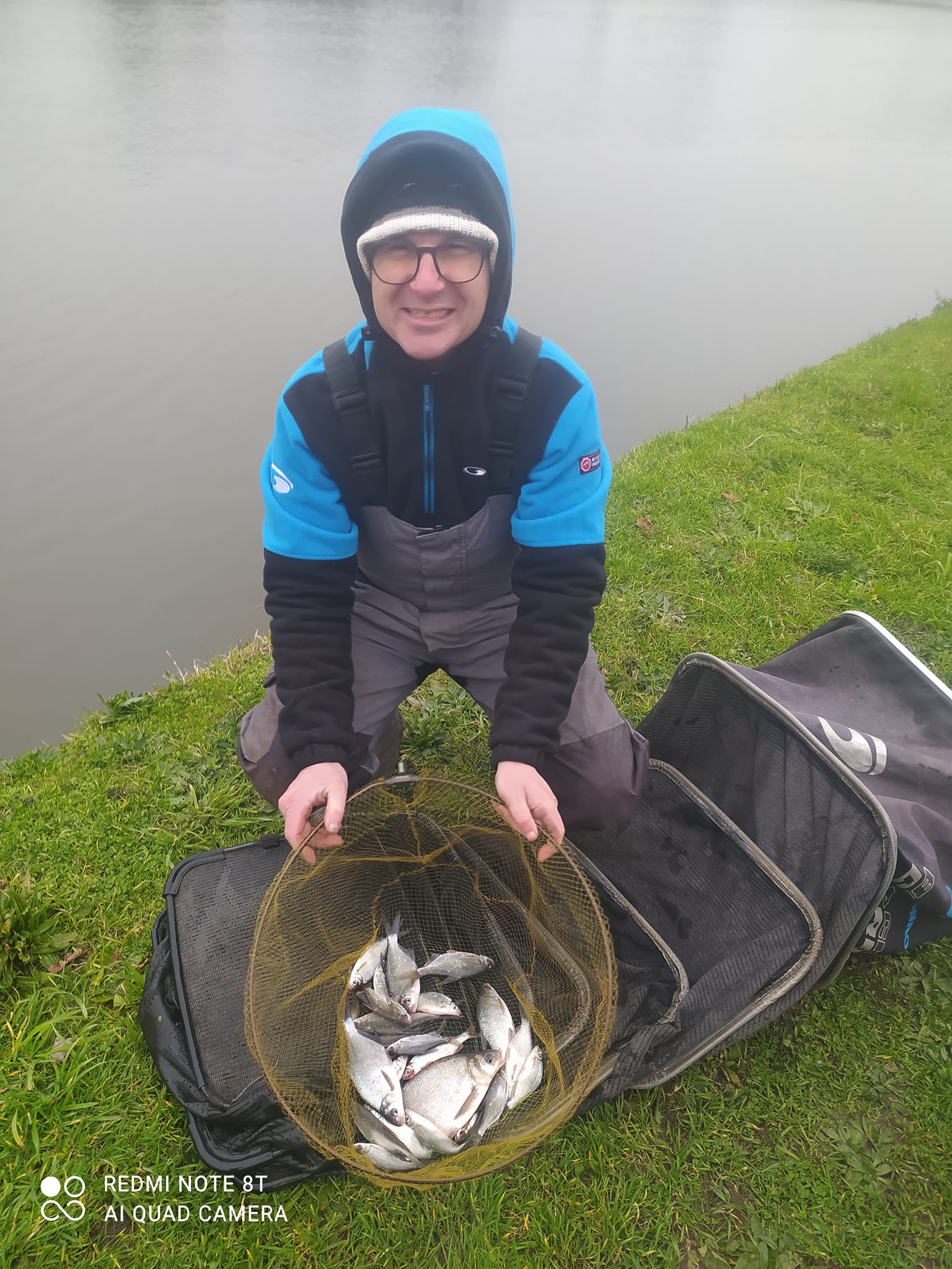 photo d'un homme et d'une bourriche pleine de poissons