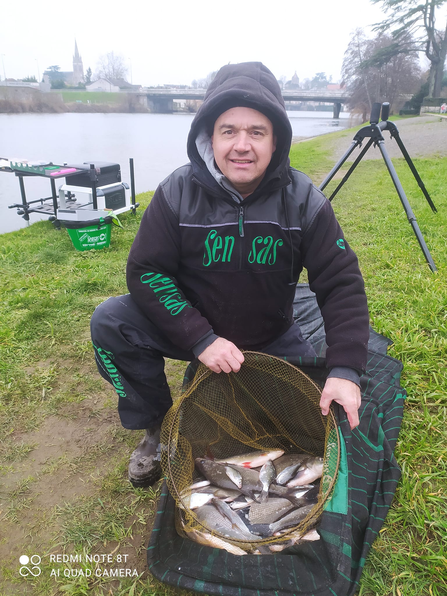 photo d'un homme à capuche et une bourriche pleine de poissons