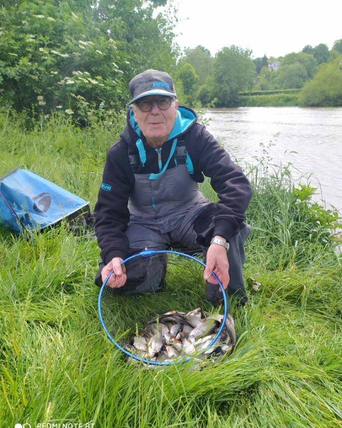 viel homme avec une bourriche pleine de poissons